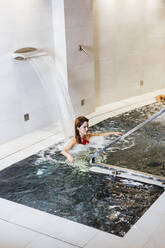 Woman enjoying the whirlpool in a spa - LJF00398