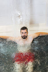 Man enjoying the whirlpool in a spa - LJF00401