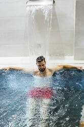 Man enjoying the whirlpool in a spa - LJF00402