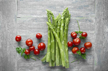 Grüner Spargel und Kirschtomaten auf Holztisch von oben gesehen - ASF06456