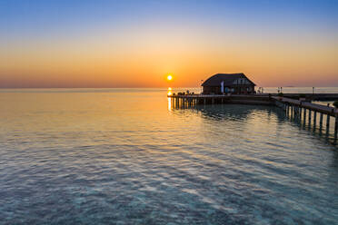 Maldives, Olhuveli island, Pier and diving school building on South Male Atoll lagoon at sunset - AMF07146