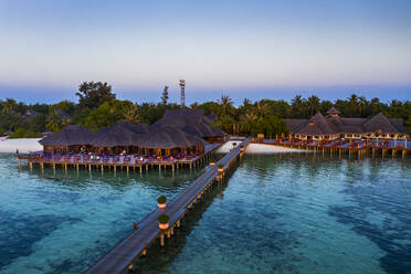 Malediven, Insel Olhuveli, Pier und Resort in der Lagune des Süd Male Atolls bei Sonnenuntergang - AMF07147