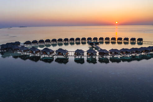 Malediven, Insel Olhuveli, Resort-Bungalows in der Lagune des Süd Male Atolls bei Sonnenuntergang - AMF07148