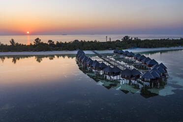 Maldives, Olhuveli island, Resort bungalows on South Male Atoll lagoon at sunset - AMF07151