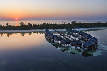 Malediven, Insel Olhuveli, Resort-Bungalows in der Lagune des Süd Male Atolls bei Sonnenuntergang - AMF07151
