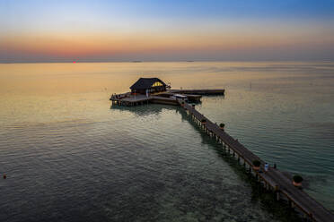 Malediven, Insel Olhuveli, Pier und Gebäude in der Lagune des Süd Male Atolls bei Sonnenuntergang - AMF07156