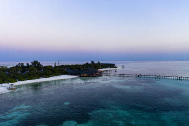 Malediven, Insel Olhuveli, Pier und Resort in der Lagune des Süd Male Atolls bei Sonnenuntergang - AMF07157
