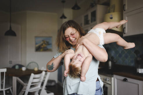 Portrait of mother playing with her little son in the kitchen - EYAF00300