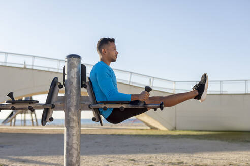 Mann beim Workout an einem Fitnessgerät im Freien - MAUF02646