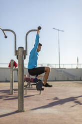 Mann beim Workout an einem Fitnessgerät im Freien - MAUF02648