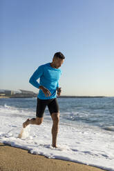 Man jogging on the beach - MAUF02652