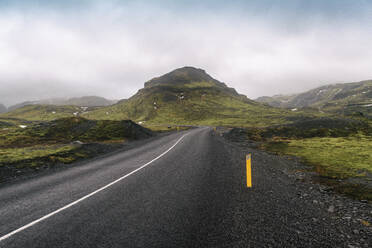 Island, Südisland, Leere Straße Solheimajokulsvegur an einem bewölkten Tag - TAMF01731