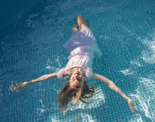 Germany, Brandenburg, Teenage girl floating in pool - BFRF02051