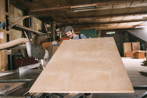 Carpenter checking wooden board - VPIF01315