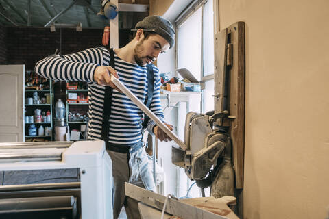 Schreiner bei der Arbeit an einer Schleifmaschine, lizenzfreies Stockfoto