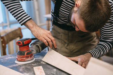 Carpenter at work, grinding wood - VPIF01371