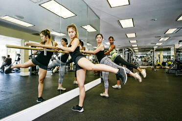 Women working out at barre in gymnasium - BLEF09506