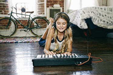 Amerikanisches Mädchen spielt Keyboard im Schlafzimmer - BLEF09529