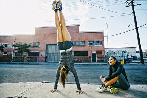 Athlete doing handstand on sidewalk - BLEF09572