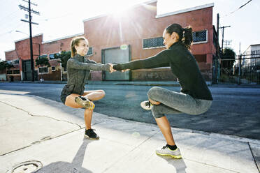 Athletes balancing on sidewalk - BLEF09574
