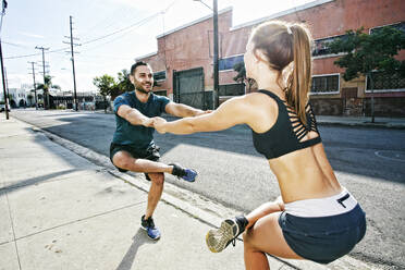 Caucasian athletes balancing on sidewalk - BLEF09575