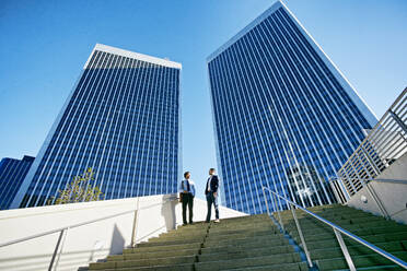 Businessmen talking under highrise buildings - BLEF09601