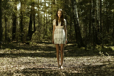 Barefoot Caucasian woman standing in forest - BLEF09653