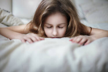 Kaukasisches Teenager-Mädchen auf dem Bett liegend - BLEF09673