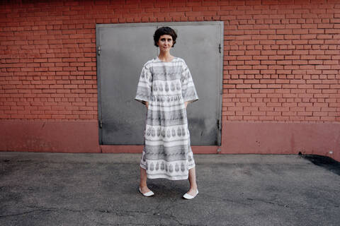 Russia, Moscow, Portrait of woman standing by brick wall stock photo