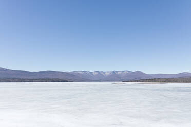 Landschaftliche Ansicht des gefrorenen Eises auf dem Ashokan-Stausee vor einem strahlend blauen Himmel - MMAF01078