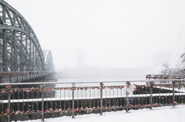 Vorhängeschlösser am Geländer der Hohenzollernbrücke über den Rhein gegen den Himmel bei Schneefall - GWF06146