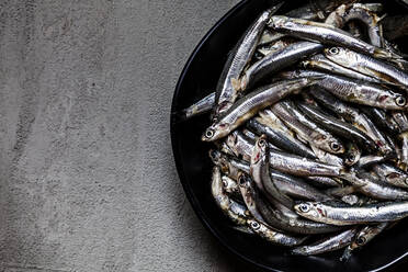 Nahaufnahme von frischen Anchovis in einer Schale auf Beton - SBDF03977