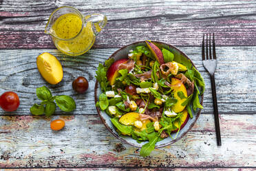 Directly above view of fresh salad bowl with fork and pitcher on table - SARF04334