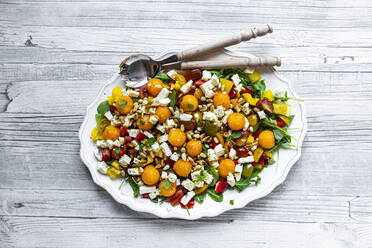 Hohe Winkel Ansicht der gesunden Salat mit Löffeln in Teller auf Holztisch - SARF04336