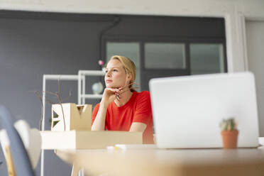 Young woman in office thinking with architectural model on desk - JOSF03451