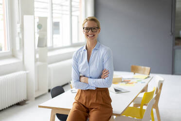 Portrait of smiling young businesswoman in office - JOSF03455