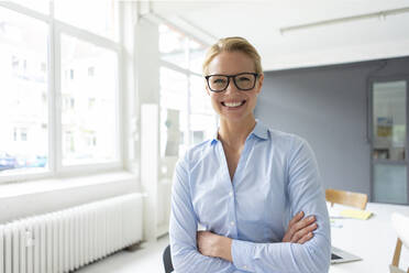 Portrait of smiling young businesswoman in office - JOSF03456