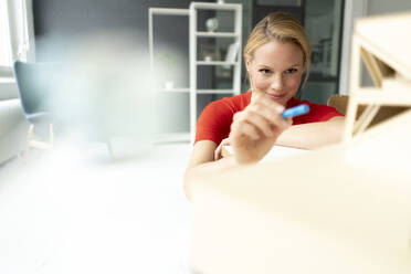 Young woman in office with architectural model on desk - JOSF03475