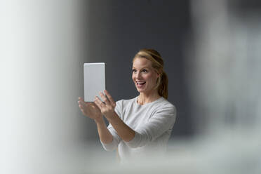 Happy young woman holding tablet - JOSF03511