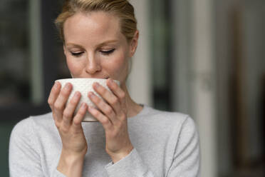 Junge Frau hält einen Kaffeebecher - JOSF03518