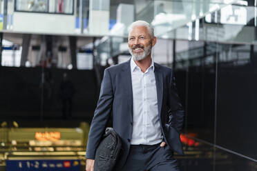 Smiling mature businessman with bag in the city - DIGF07441