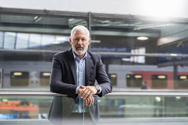 Porträt eines reifen Geschäftsmannes auf dem Bahnsteig - DIGF07457