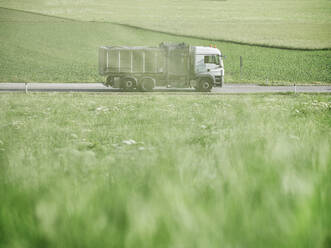 Truck moving on highway along green field during sunny day - CVF01266