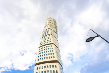 Niedriger Blickwinkel des sich drehenden Oberkörpers gegen bewölkten Himmel - TAMF01793