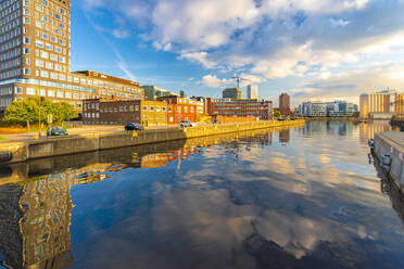 Buildings reflecting in canal by Oeresund in city against sky - TAMF01801