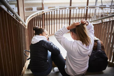 Male and female teenage friends sitting on steps - MASF12839