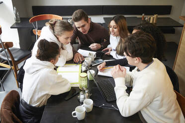 Male and female friends studying at table in cafe - MASF12841