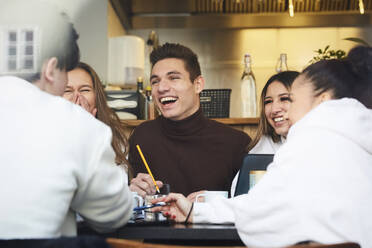 Männliche und weibliche Teenager-Freunde lächelnd beim Lernen am Tisch im Cafe - MASF12850