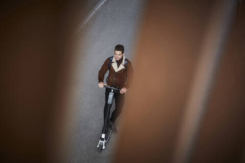 Hohe Winkel Ansicht der Teenager-Junge Reiten elektrische Push-Roller auf der Straße, lizenzfreies Stockfoto