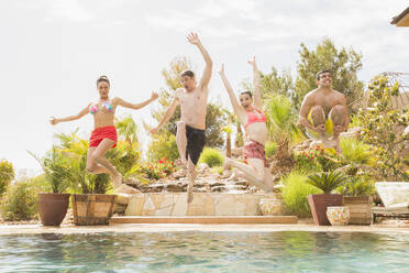 Friends jumping into swimming pool - BLEF09719